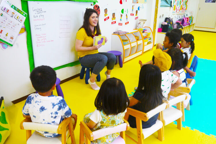 外国人講師が子どもたちに英語の絵本を読んでいる