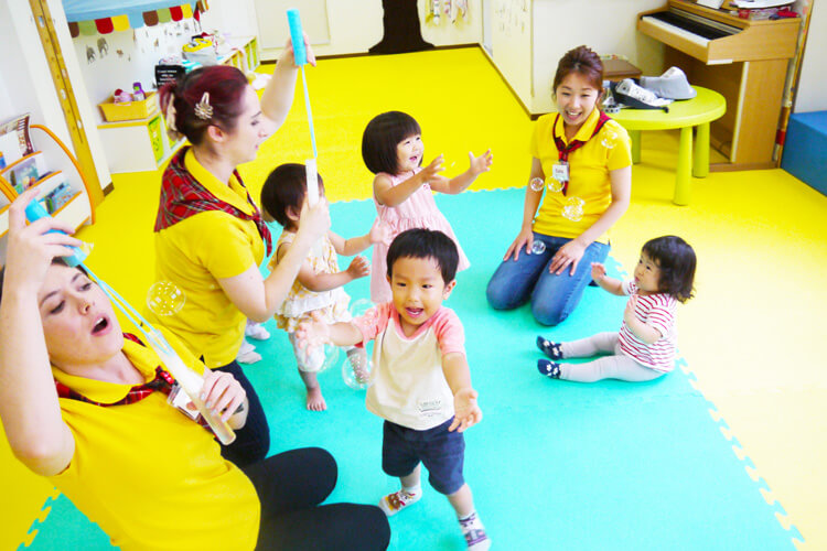 子どもたちと講師がしゃぼん玉で遊ぶ